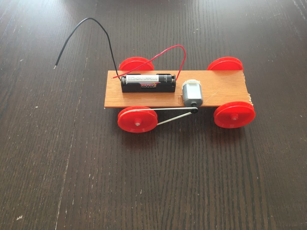 A toy car with wheels and batteries on it.