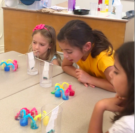 A group of children sitting at a table with toys.