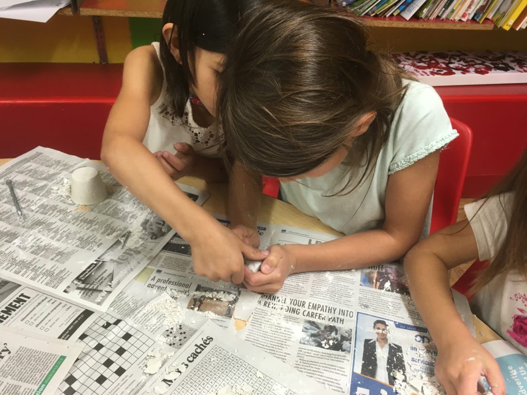 Two girls extracting fossils