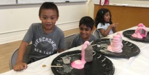 A group of kids sitting at the table with food.