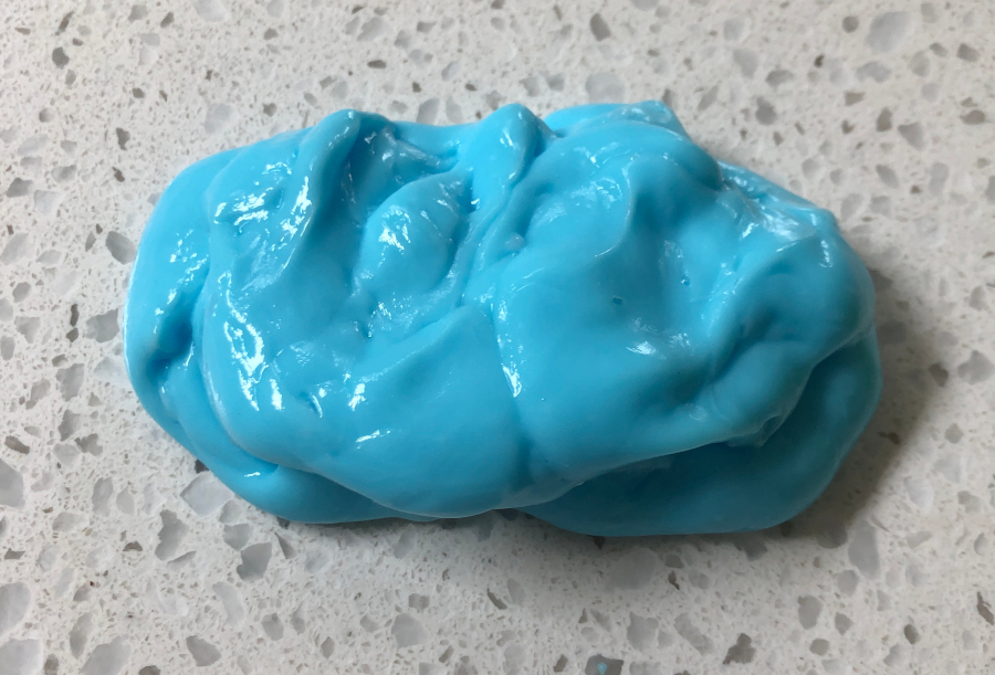 A blue ball of dough sitting on top of a table.