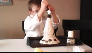 A boy is decorating a cake with icing.