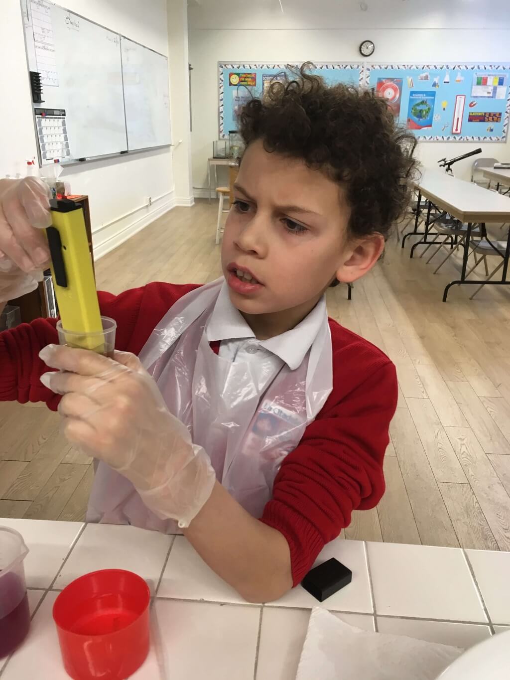 A boy in red shirt holding up yellow object.