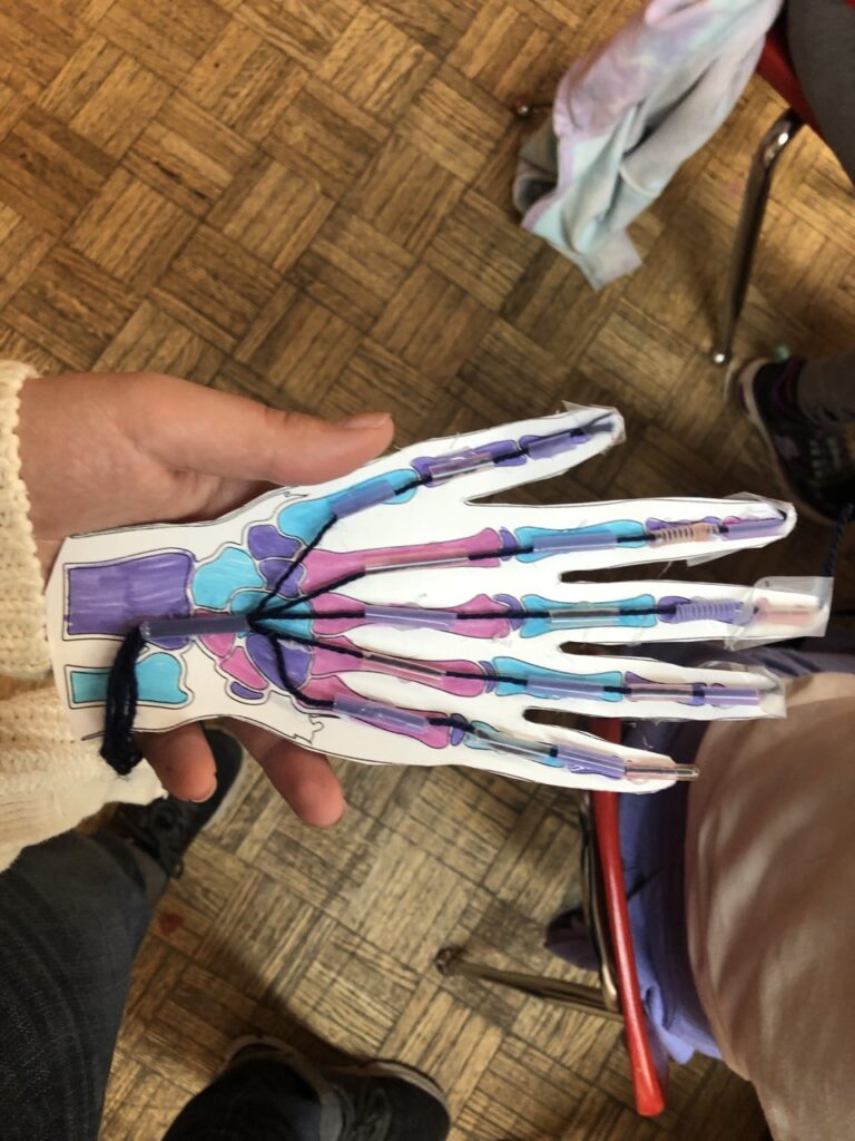 A person holding up their hand with paint on it.