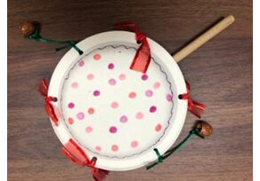 A small toy drum with red and pink polka dots.